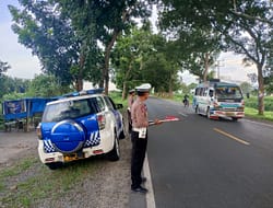 Implementasi Program Kapolri. Polantas Batu Bara Kibas Bendera di Sore Hari.